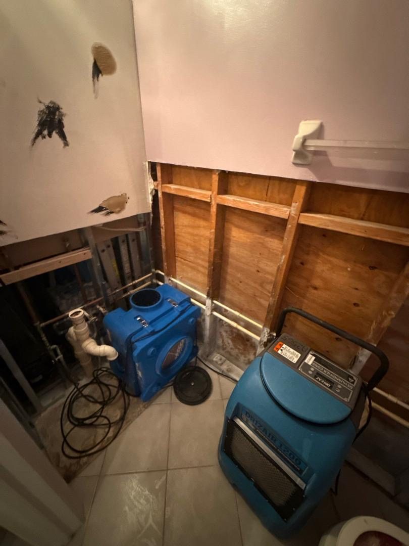 Dehumidifiers drying a bathroom demoed down to the studs